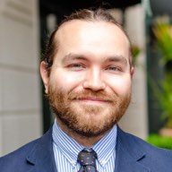 Portrait of Nolan Tecklenburg wearing a blue suit and tie